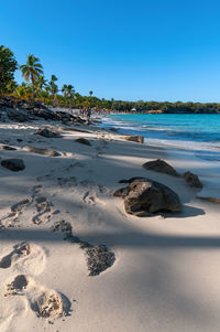 Scenic view of beach against clear blue sky