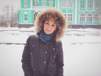 Portrait of woman wearing fur jacket on snowy field