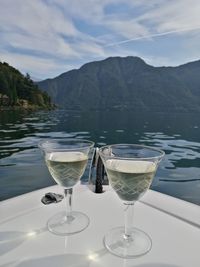 Wine glasses on table against mountains