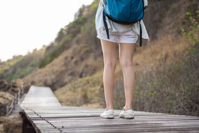 Low section of woman standing on footpath