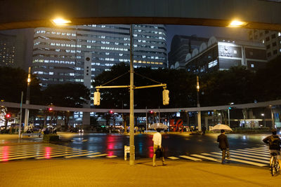 People in illuminated city at night