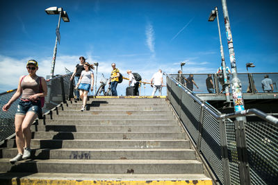 People on staircase against sky