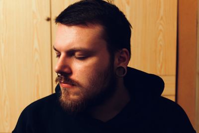 Portrait of young man looking away at home