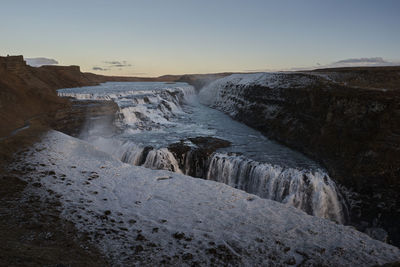 Scenic view of waterfall against sky