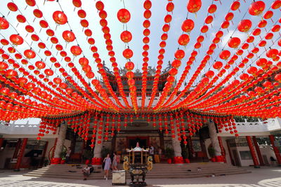 People in red lanterns hanging on building