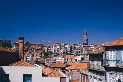 Buildings in city against clear blue sky