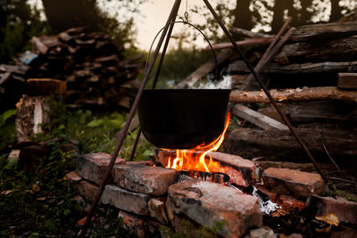 Bonfire with a pot for cooking at night in the camp. hiking and camping in the woods, cooking dinner 