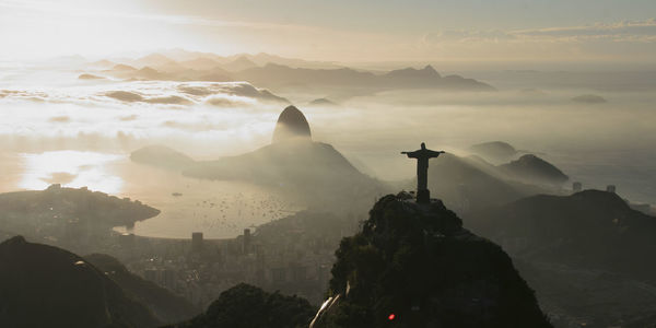 View of statue in city at sunset