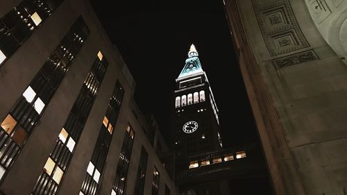 Low angle view of clock tower at night