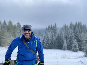 Portrait of man standing on snow covered field