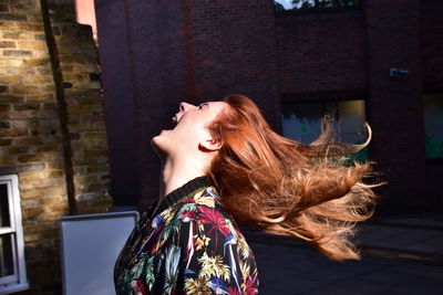 Woman with tousled hair screaming outdoors