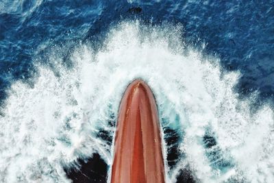 High angle view of sea waves splashing on boat