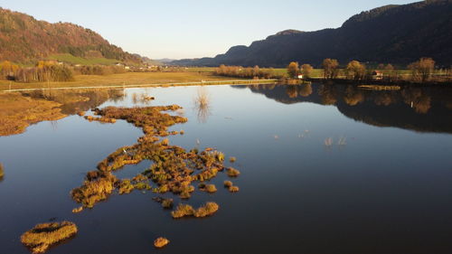 Scenic view of lake by mountains against clear sky
