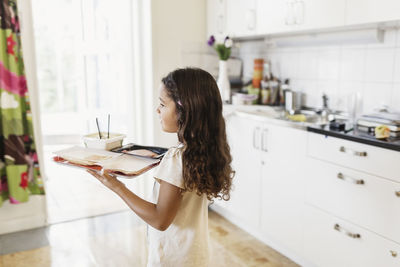 Girl carrying food in tray at day care center