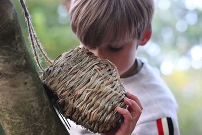 Rear view of boy holding hat