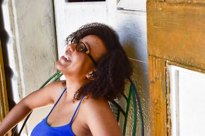 Portrait of smiling woman standing against wall