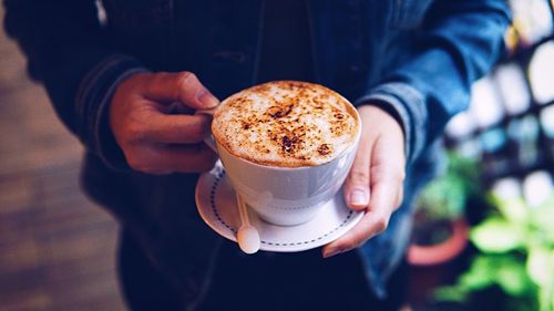 Midsection of man holding coffee cup