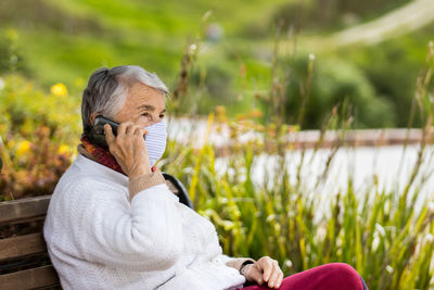 Side view of woman sitting outdoors