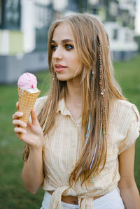 Cute girl eats ice cream from a waffle cone, soiling her lips person