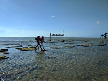 Men on beach against sky