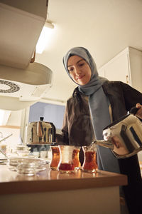 Woman preparing evening tea at home