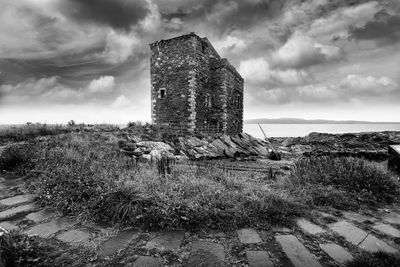 Old ruin of building on field against sky