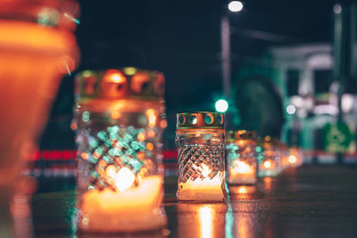 Close-up of illuminated candles on table at night