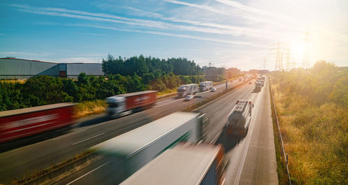 Blurred motion of vehicles on road in city against sky