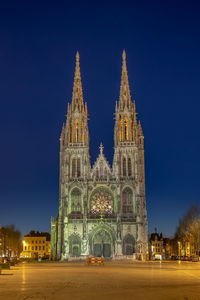 View of illuminated church of saint peter and saint paul in ostend against blue sky at night