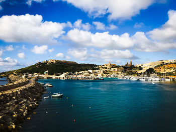 Panoramic view of city by sea against sky