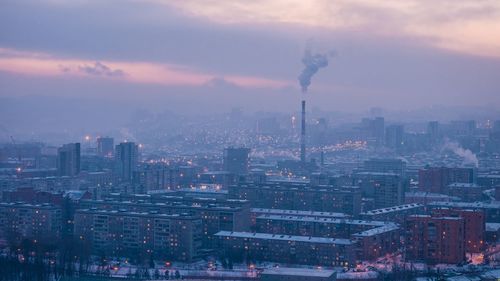 Aerial view of buildings in city against sky