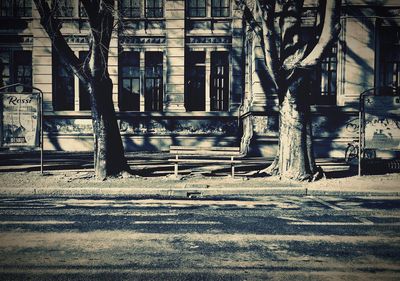 Empty road by buildings in city