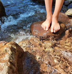Two feet on a rock in a river, running water