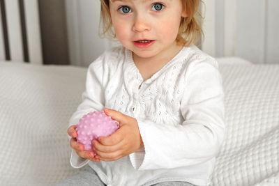 Baby girl playing tactile knobby balls. young child hand plays sensory massage ball