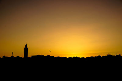 Silhouette buildings against sky during sunset