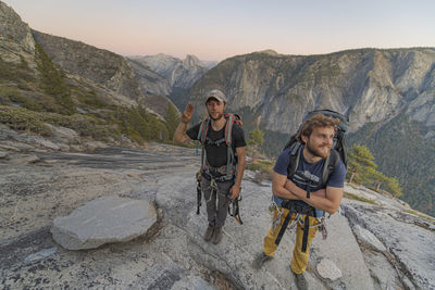 Two hikers at the top of el capitan in yosemite valley at sunset