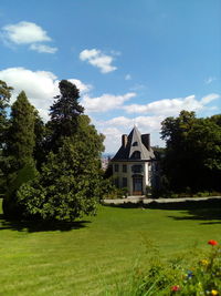 Lawn by house against sky