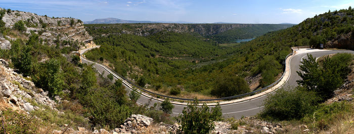 High angle view of road amidst trees against sky
