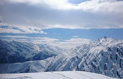 Scenic view of snow covered mountains against sky