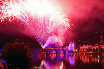 Firework display over river at night