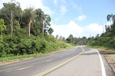 Road amidst trees against sky