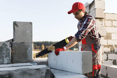 Side view of man standing against wall