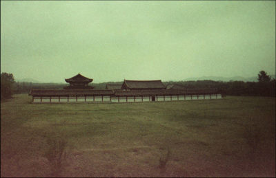 Built structure on field against sky