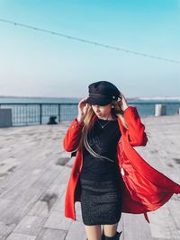 Young woman standing on river against sky