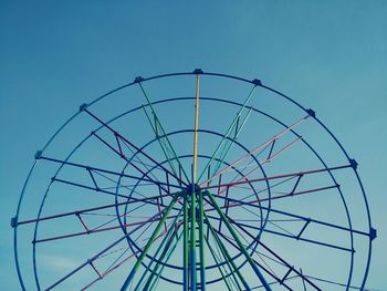 Low angle view of colorful ferris wheel against blue sky