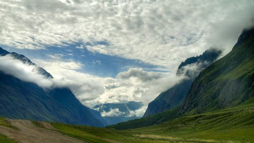 Scenic view of mountains against cloudy sky