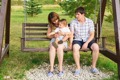 Full length of women sitting on bench in park