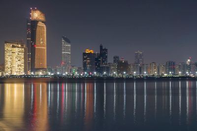 Illuminated buildings against sky at night