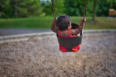 Girl playing with swing in playground