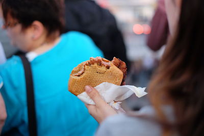 Midsection of woman holding sandwich